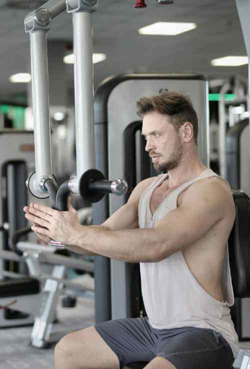 Muscls salonunda barbell ile kuvvet antrenmanı yapan sporcular